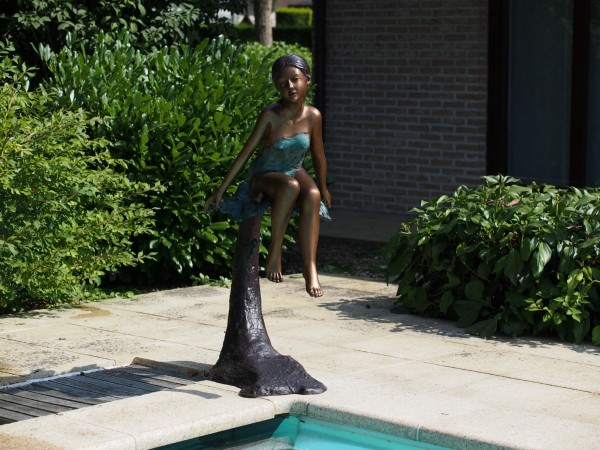 Mädchen sitzend auf Baumstamm als Bronzefigur 115 cm